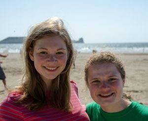 two high school girls standing on a beach