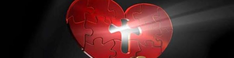red heart-shaped puzzle; a missing piece in the middle in the shape of a cross with light shining through