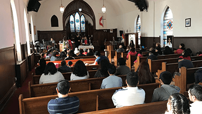 picture of a small congregation worshiping in a sanctuary.